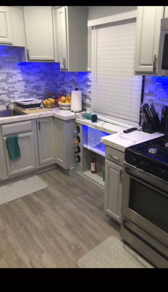 Kitchen after — white and gray cabinets with blue LED under-cabinet lighting